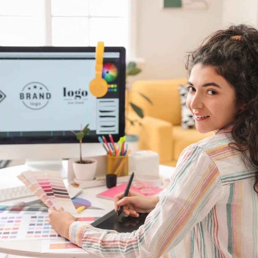 Androcraft graphic design service - girl looking back at camera with work station background