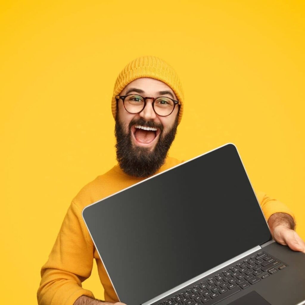 Androcraft web development service - guy holding laptop with yellow background